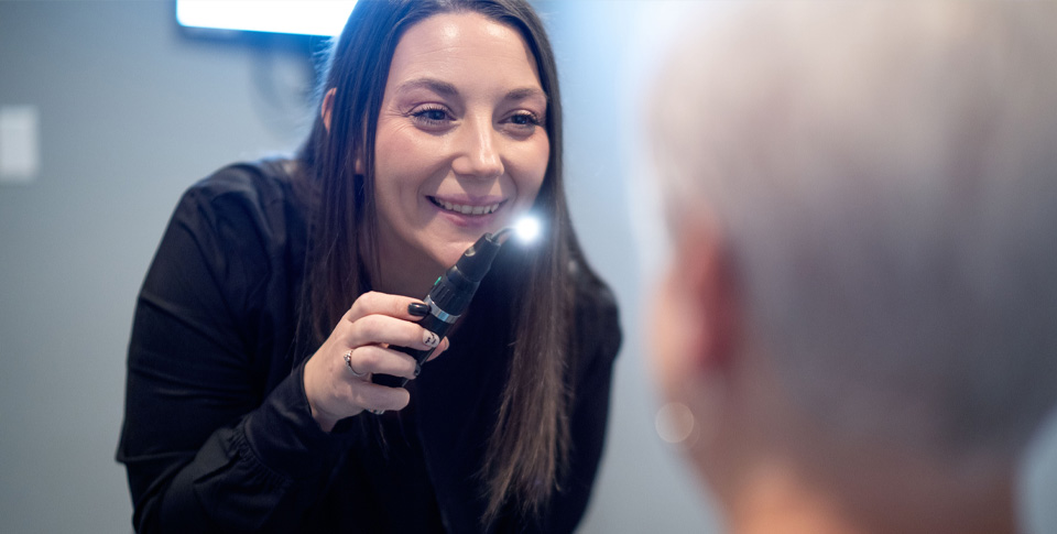 Female team member smiling at patient during eye exam